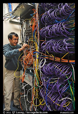 Man with tangle of wires in server room. Menlo Park,  California, USA