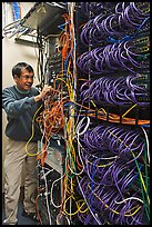 Man with tangle of wires in server room. Menlo Park,  California, USA ( color)