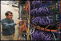 Technician rearranging data cables. Menlo Park,  California, USA ( color)