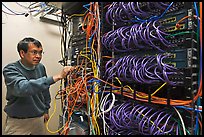 Technician rearranging data cables. Menlo Park,  California, USA (color)