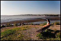 Woman sitting on bench, Carquinez Strait Regional Shoreline. Martinez, California, USA (color)