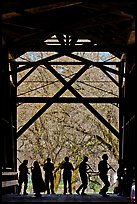Silhouettes of people dancing inside covered bridge, Felton. California, USA
