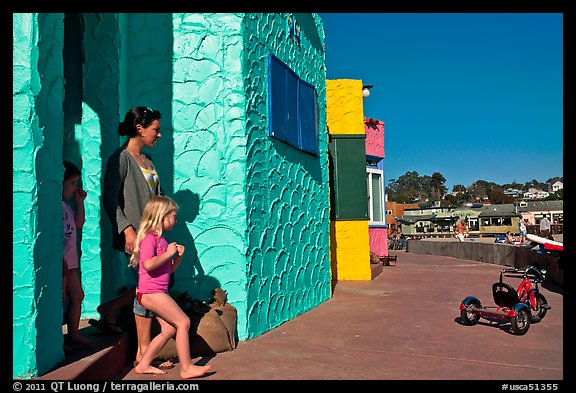 Family steps out of colorful cottage. Capitola, California, USA (color)