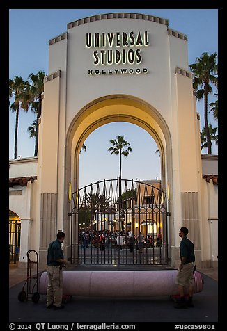 Men roll red carpet in front of Universal Studios gate. Universal City, Los Angeles, California, USA (color)