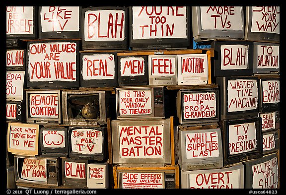 Wall of televisions covered with slogans, Slab City. Nyland, California, USA (color)