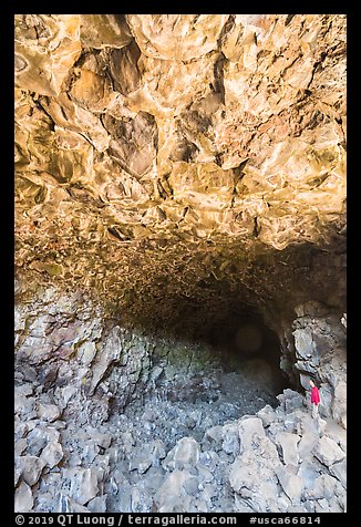 Hiker at entrance of Skull Cave. Lava Beds National Monument, California, USA (color)