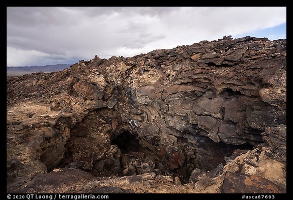 Depression and entrance to lava tube cave. Mojave Trails National Monument, California, USA (color)
