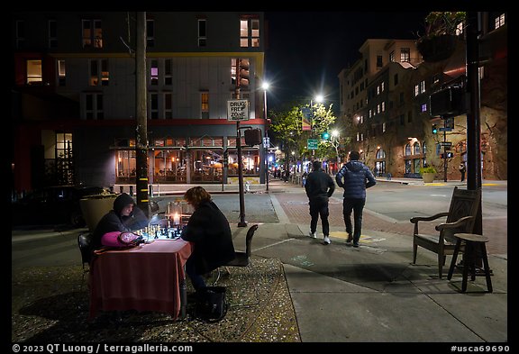 Men playing chess on Telegraph Avenue at night. Berkeley, California, USA (color)