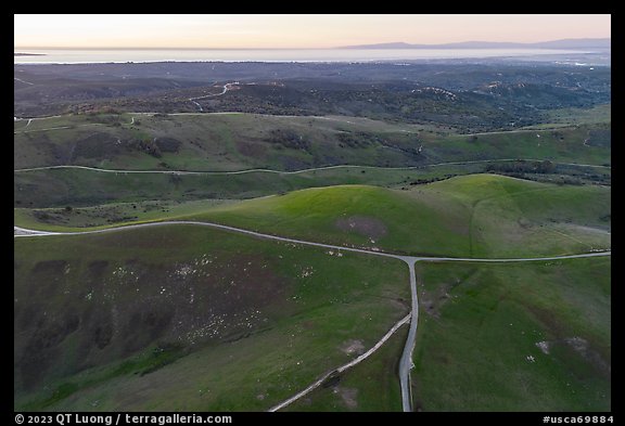 Aerial view of roads, gently rolling hills, with Pacific Ocean in the distance. California, USA (color)