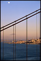 The city seen through the cables of the Golden Gate bridge, sunset. San Francisco, California, USA