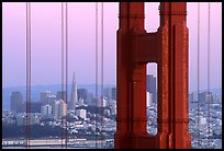 City through cables and pilars of Golden Gate bridge, dusk. San Francisco, California, USA