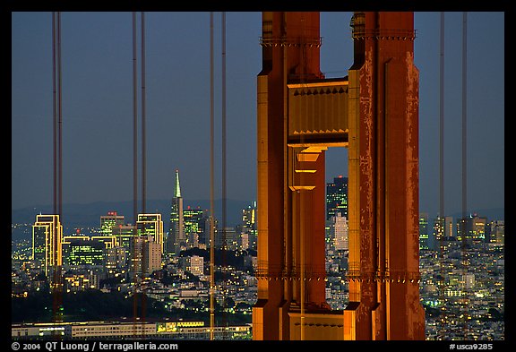 The city seen through the cables and pilars of the Golden Gate bridge, night. San Francisco, California, USA