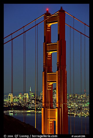 The city seen through the cables and pilars of the Golden Gate bridge, night. San Francisco, California, USA (color)