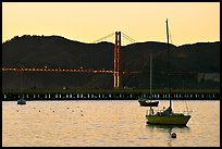 Sailboat in the Marina, with Golden Gate Bridge at sunset in the background. San Francisco, California, USA (color)