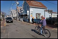 Woman biking on main street, Provincetown. Cape Cod, Massachussets, USA (color)