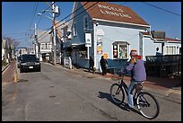 Woman biking on main street, Provincetown. Cape Cod, Massachussets, USA