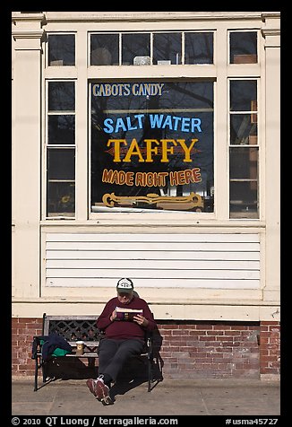 Man reading in front of Salt Water taffy store, Provincetown. Cape Cod, Massachussets, USA (color)