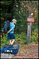 Backpacker shouldering pack at trailhead. Maine, USA (color)