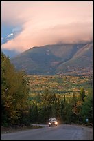 Truck on road below cloud-capped Katahdin. Maine, USA