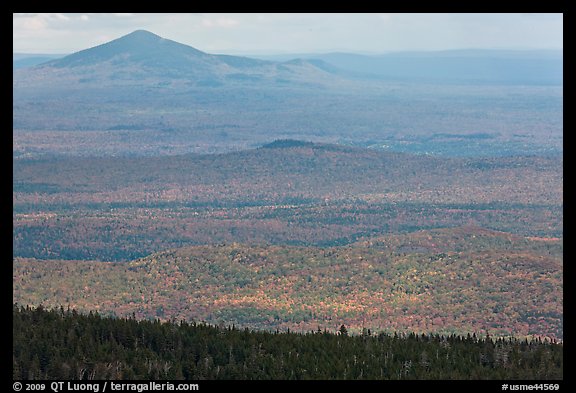 Distant hills rising above forested slopes in fall foliage. Baxter State Park, Maine, USA (color)