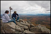 Hikers taking in view near sign marking summit of South Turner Mountain. Baxter State Park, Maine, USA