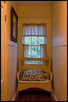 Corridor in inn with chair and window looking out to trees. Maine, USA