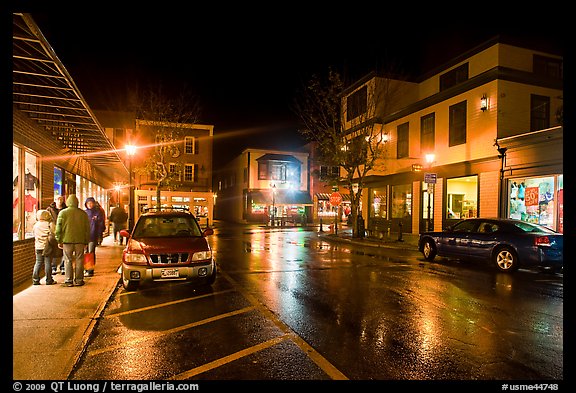 Street at night with people standing on sidewalk. Bar Harbor, Maine, USA (color)