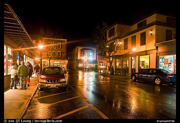 Street at night with people standing on sidewalk. Bar Harbor, Maine, USA