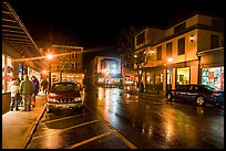 Street at night with people standing on sidewalk. Bar Harbor, Maine, USA (color)