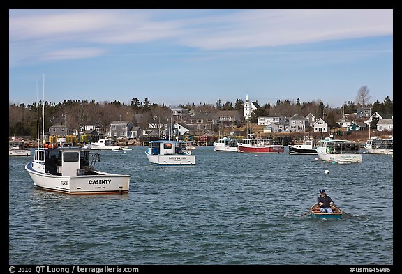 Man paddling to board lobster boat. Corea, Maine, USA (color)