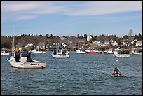 Man paddling to board lobster boat. Corea, Maine, USA