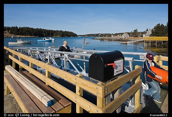 Mailbox and people unloading mailboat. Isle Au Haut, Maine, USA