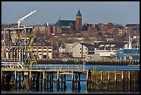 Pier and hillside buildings across harbor. Portland, Maine, USA