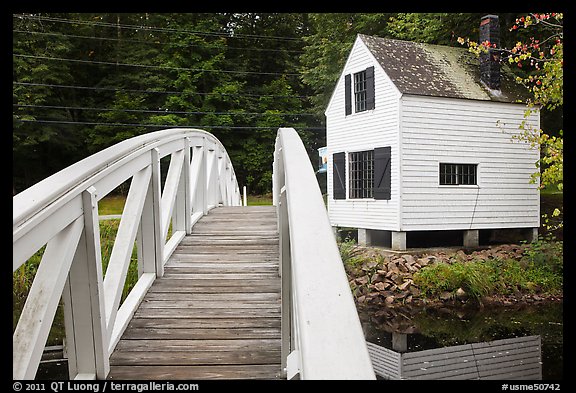 Wooden arched footbridge and house. Maine, USA