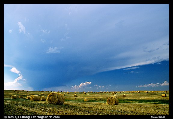 Storm cloud and hay rolls. North Dakota, USA