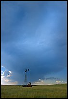 Windmill and tractor under a threatening stormy sky. North Dakota, USA (color)