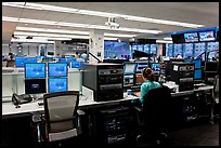 Bloomberg News analyst working in front of many screens. NYC, New York, USA