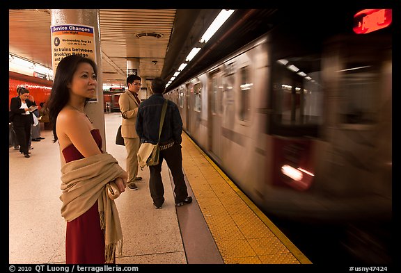 Young woman and arriving train on subway platform. NYC, New York, USA (color)