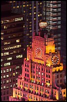 Top of vintage high-rise building with globe and clocks. NYC, New York, USA