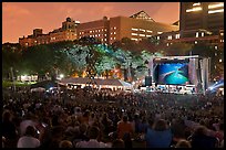 Outdoor musical performance at night with QTL photo as screen backdrop, Central Park. NYC, New York, USA (color)