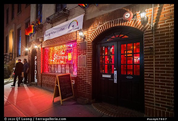 Two men on sidewalk and Stonewall Inn at night, Stonewall National Monument. NYC, New York, USA (color)