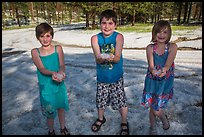 Children in summer dress holding large hailstones, Black Hills National Forest. Black Hills, South Dakota, USA (color)