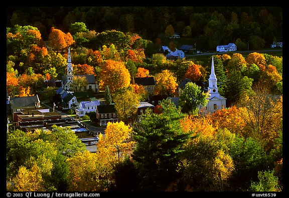 Village surounded by trees in brilliant autumn foliage. Vermont, New England, USA