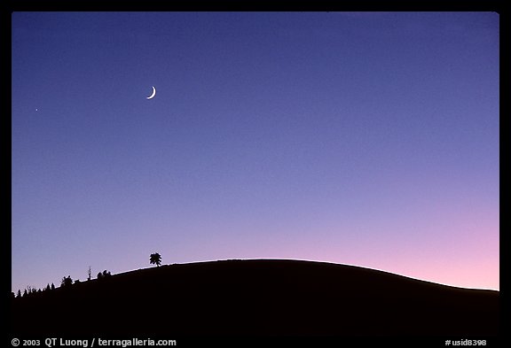 Curve of cinder cone, pastel sky, and moon. Craters of the Moon National Monument and Preserve, Idaho, USA (color)