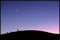 Curve of cinder cone, pastel sky, and moon. Craters of the Moon National Monument and Preserve, Idaho, USA