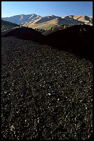 Dark pumice, cinder cones, and Pioneer Mountains. Craters of the Moon National Monument and Preserve, Idaho, USA