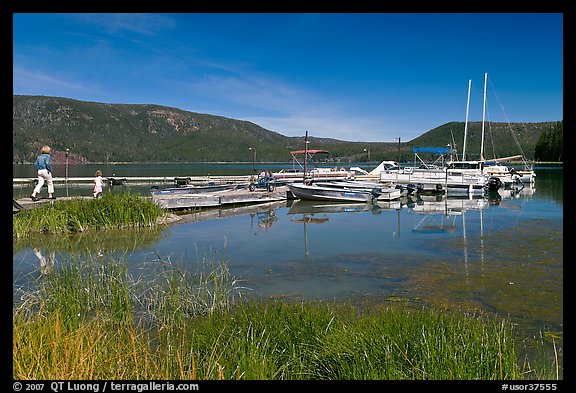 Family walking on deck towards boats, Paulina Lake. Newberry Volcanic National Monument, Oregon, USA (color)