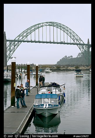 Couple holding small boat at boat lauch ramp. Newport, Oregon, USA (color)