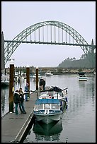 Couple holding small boat at boat lauch ramp. Newport, Oregon, USA (color)