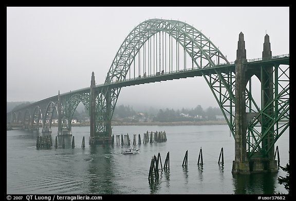 Small boat exiting harbor under Yaquina Bay Bridge. Newport, Oregon, USA